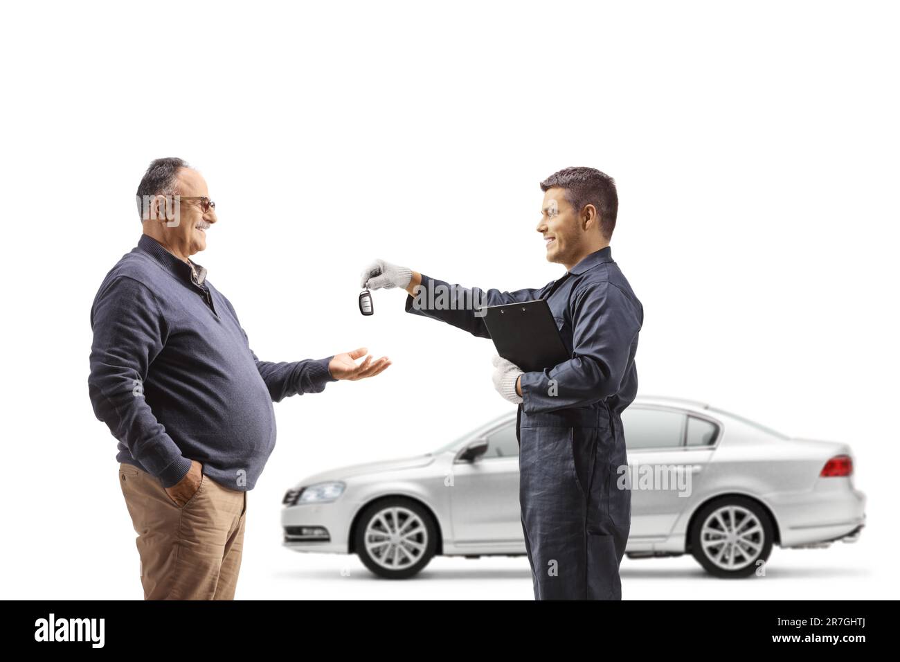 Automechaniker, der einem erwachsenen Mann einen Autoschlüssel zurückgibt, isoliert auf weißem Hintergrund Stockfoto