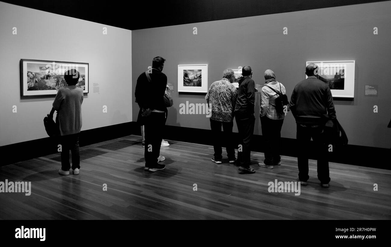 Besucher und Besucher, die Bilder der Ansel Adams in unserer Zeitfotografie-Ausstellung im de Young Museum in San Francisco, Kalifornien, betrachten. Stockfoto