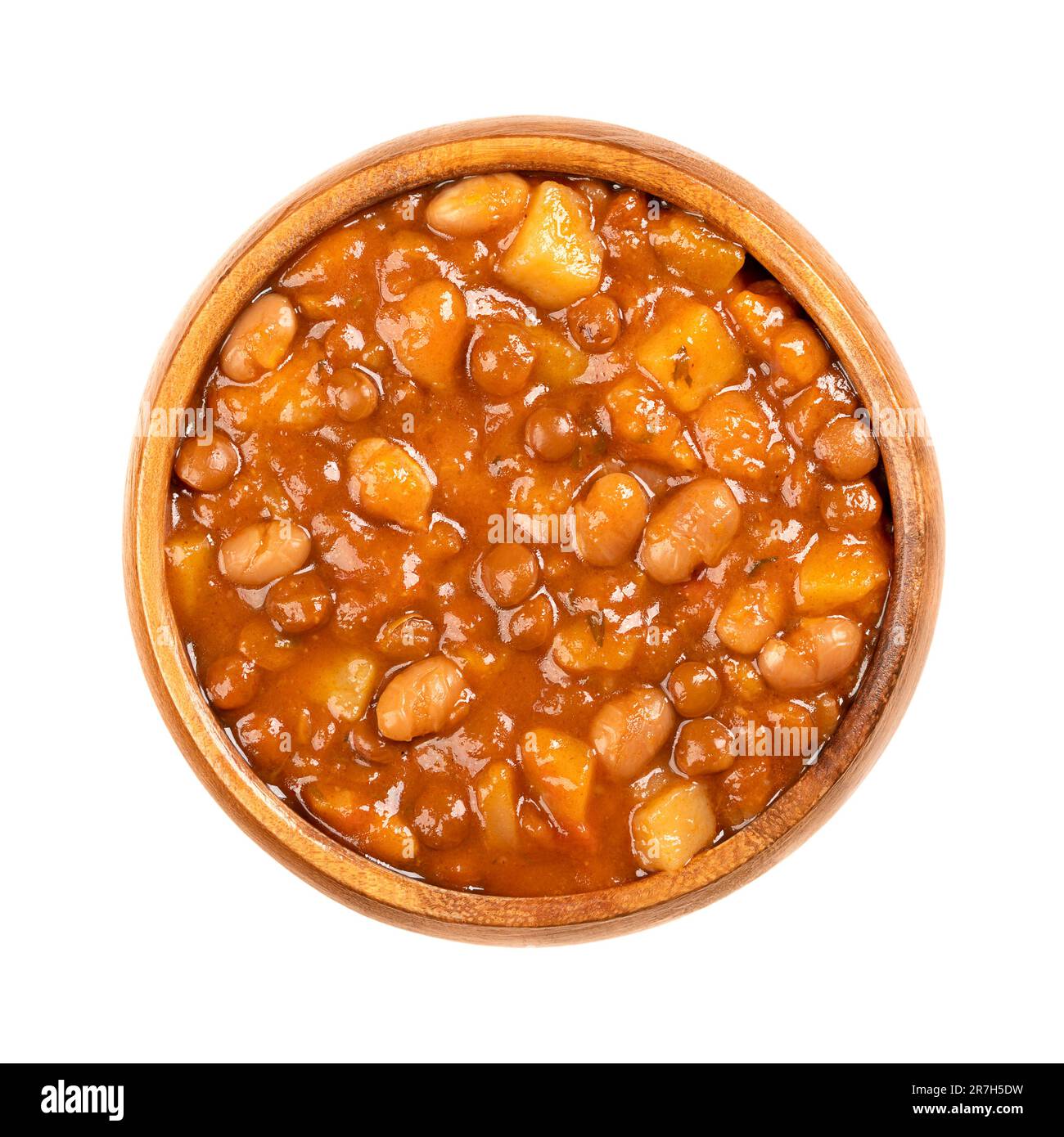 Linsen und Bohneneintopf in einer Holzschüssel. Französischer Eintopf mit braunen Linsen, weißen Bohnen, Kartoffeln, Tomaten, Zwiebeln und Kräutern, In Flüssigkeit gekocht. Stockfoto