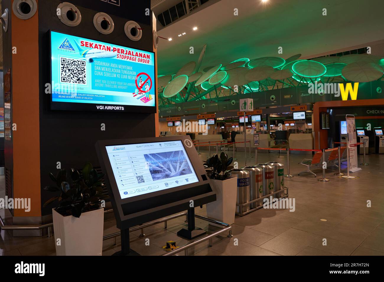 KUALA LUMPUR, MALAYSIA - CA. MÄRZ 2023: Informationsstand und Recyclingbehälter für Selbstbedienungszwecke, wie sie beim Check-in-Bereich in Kuala Lumpur International A zu sehen sind Stockfoto