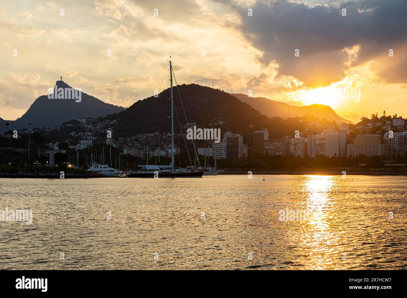 Blick auf den goldenen Sonnenuntergang von der Almirante Silvio de Noronha Avenue, in der Nähe des Flughafens Santos Dumont der Küste des Viertels Gloria unter dem späten WolkenHimmel im Sommer. Stockfoto