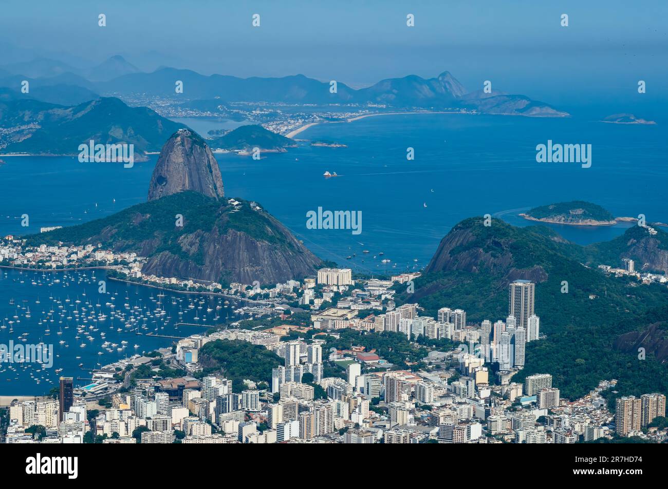 Weiter Blick auf den Zuckerhut und die Naturdenkmäler des Urca-Hügels und das Botafogo-Viertel, wie man ihn vom Gipfel des Corcovado unter dem blauen Sommerhimmel sieht. Stockfoto