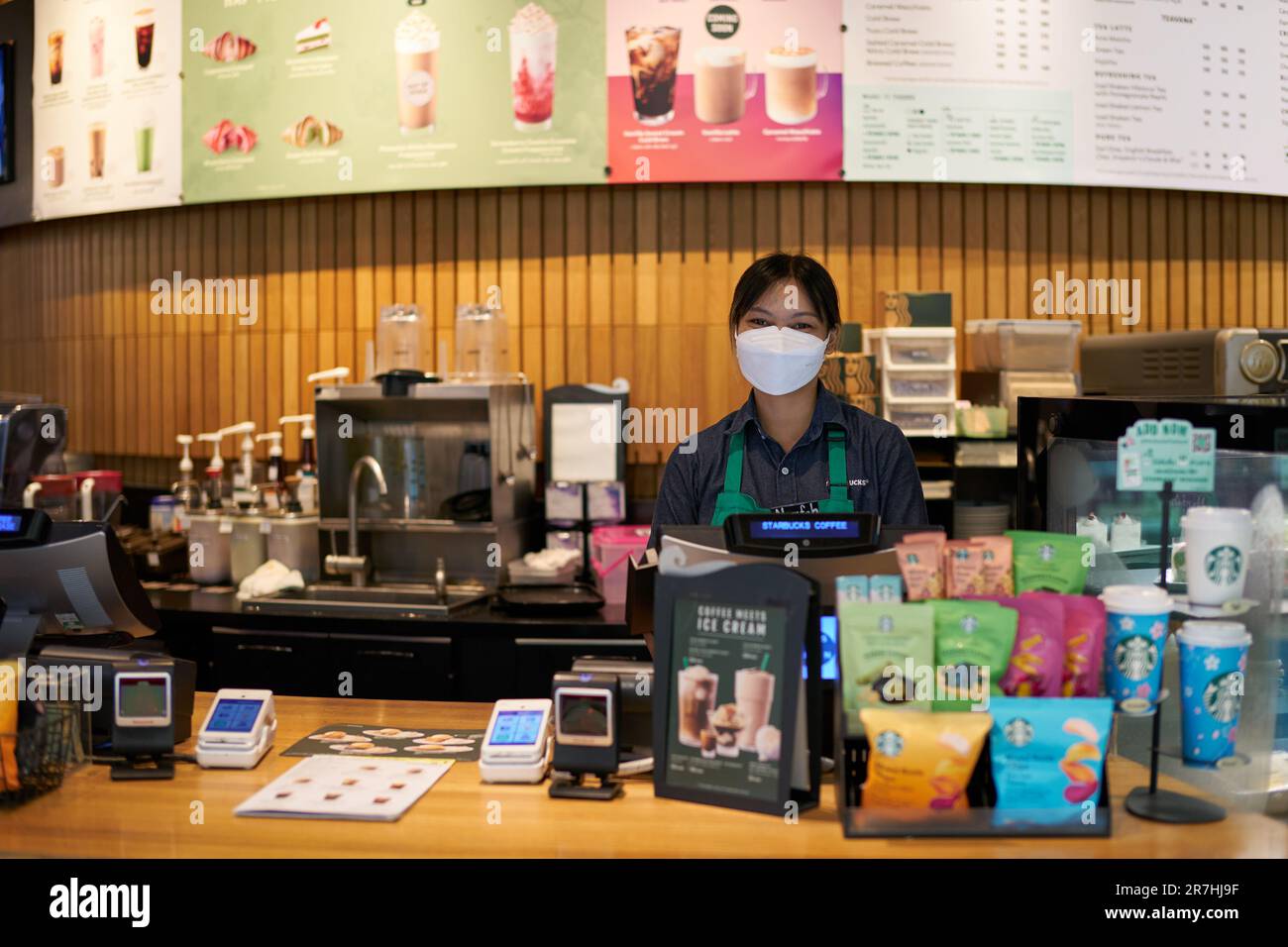 BANGKOK, THAILAND - CIRCA APRIL 2023: Innenporträt eines Mitarbeiters, der in die Kamera schaut, bei Starbucks Coffee im Einkaufszentrum Siam Discovery. Stockfoto