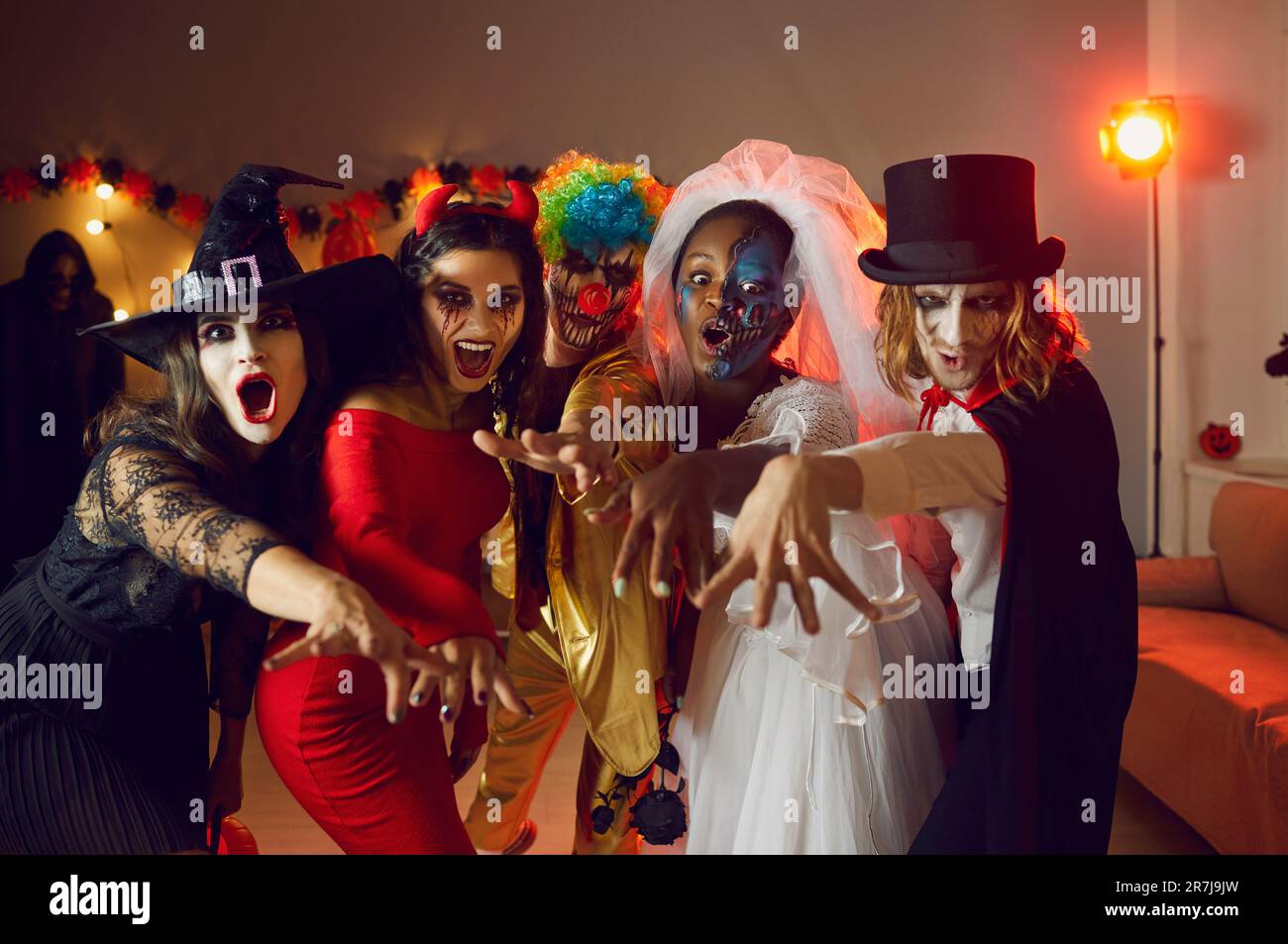 Gruppenporträt von jungen Freunden in gruseligen Halloween-Kostümen, in denen "BUH alle zusammen" steht Stockfoto