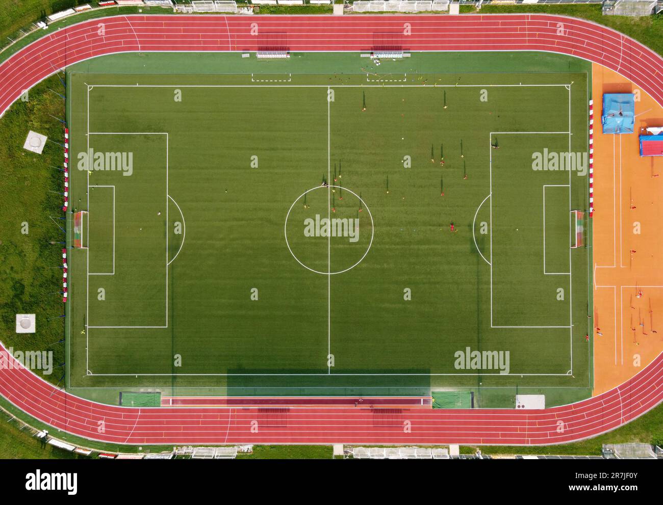 Vogelperspektive von oben auf das Sportcenter für Fußballspiele mit Spielern, die auf grünem Gras laufen Stockfoto