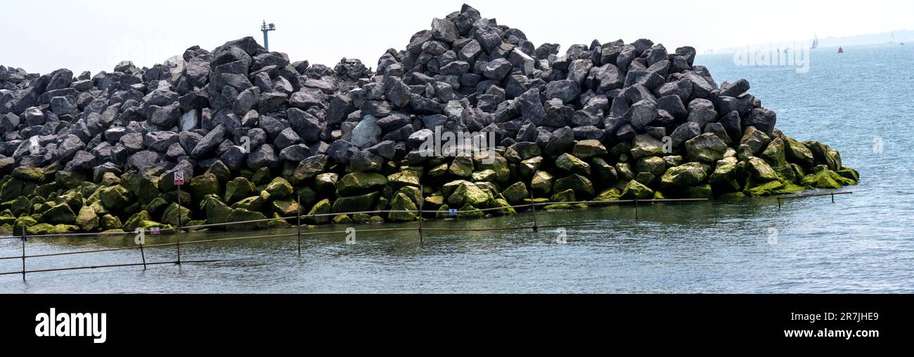 Granitfelsen an der Küste der Clarence Parade, Southsea Seafront, die als Teil der Küstenabwehr verwendet werden, Southsea, Portsmouth, Hampshire, Großbritannien. Stockfoto