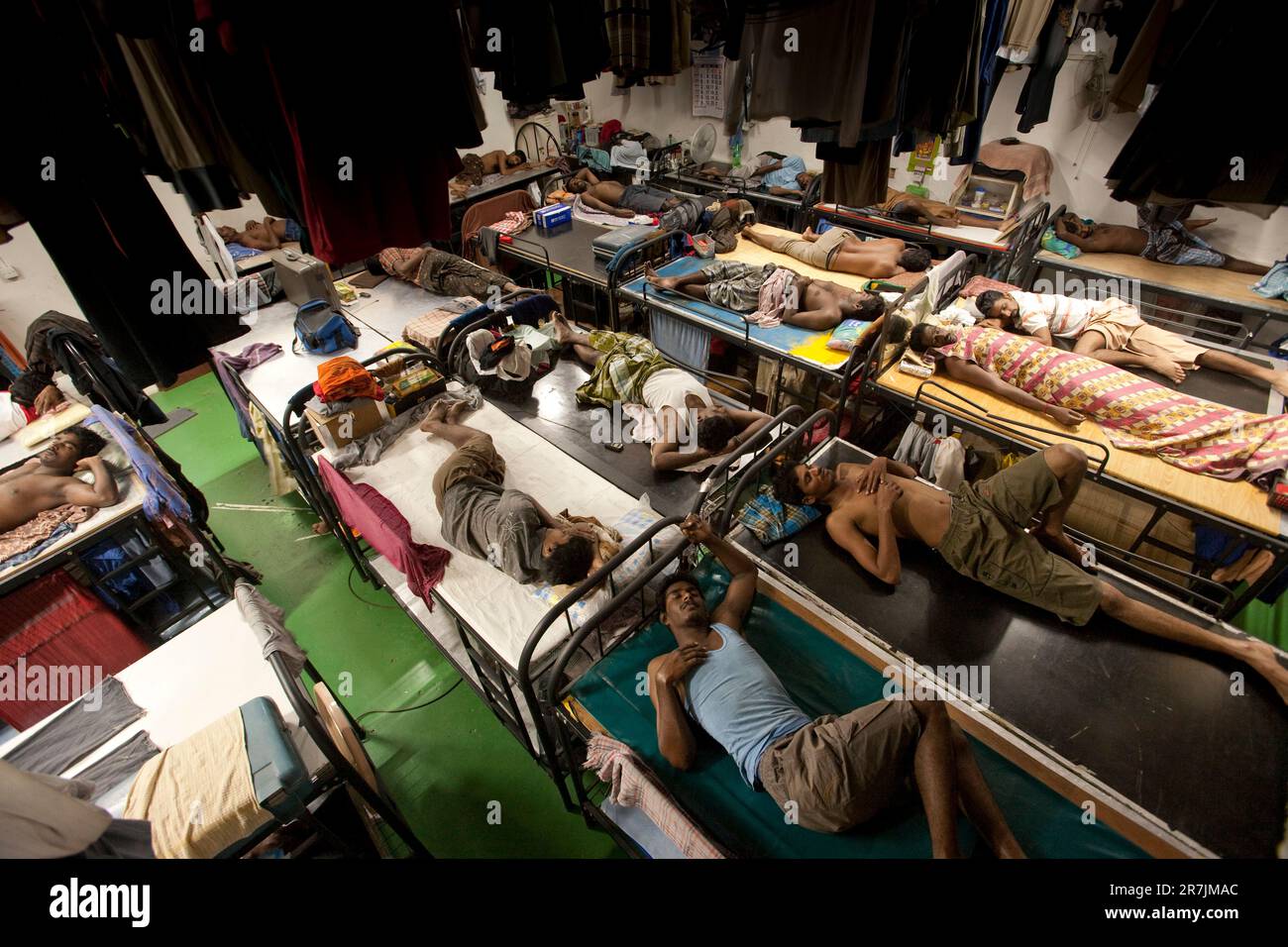 Ausländische Arbeiter schlafen 50 in einem Zimmer in einem provisorischen Wohnkomplex in Singapur. Stockfoto