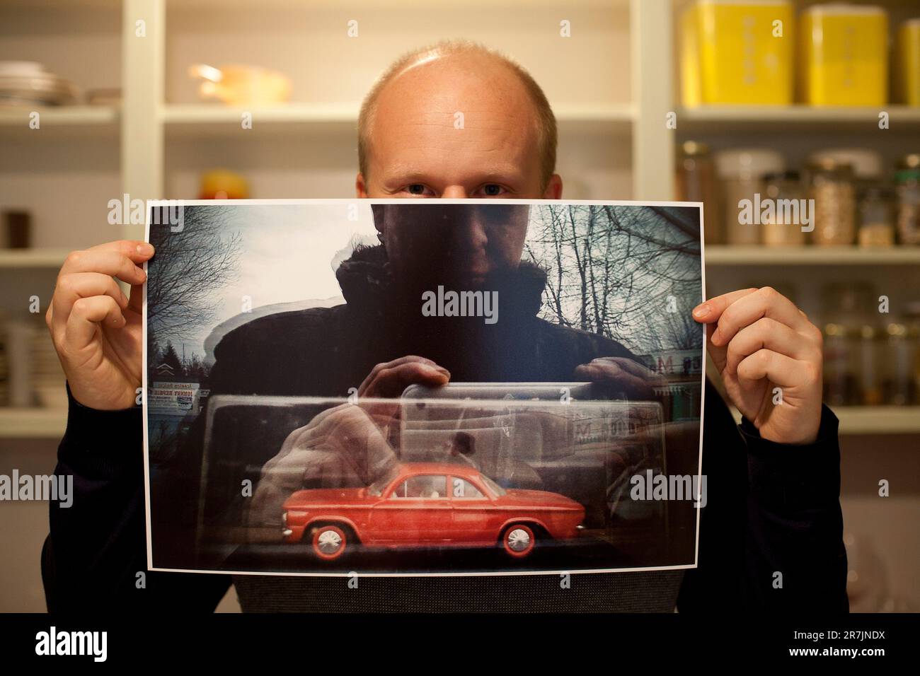 Ein Mann hält ein Foto hoch, das er mit seinem Handy aufgenommen hat, mit einer Fensterspiegelung, in der er die Fotos in Seattle, Washington, macht. Stockfoto