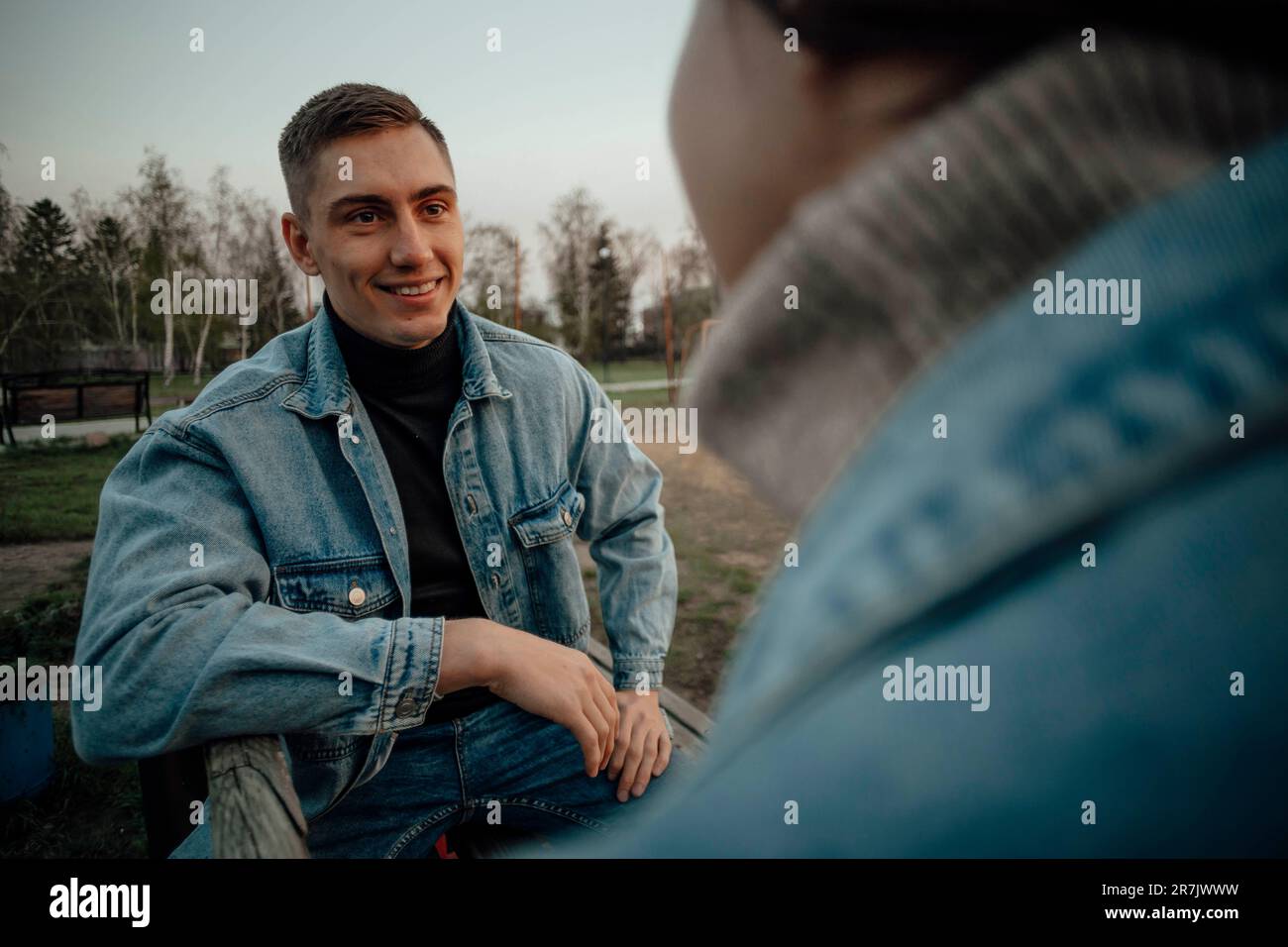 Nahaufnahme eines lächelnden, wunderschönen jungen Paares auf der Bank im Park Stockfoto