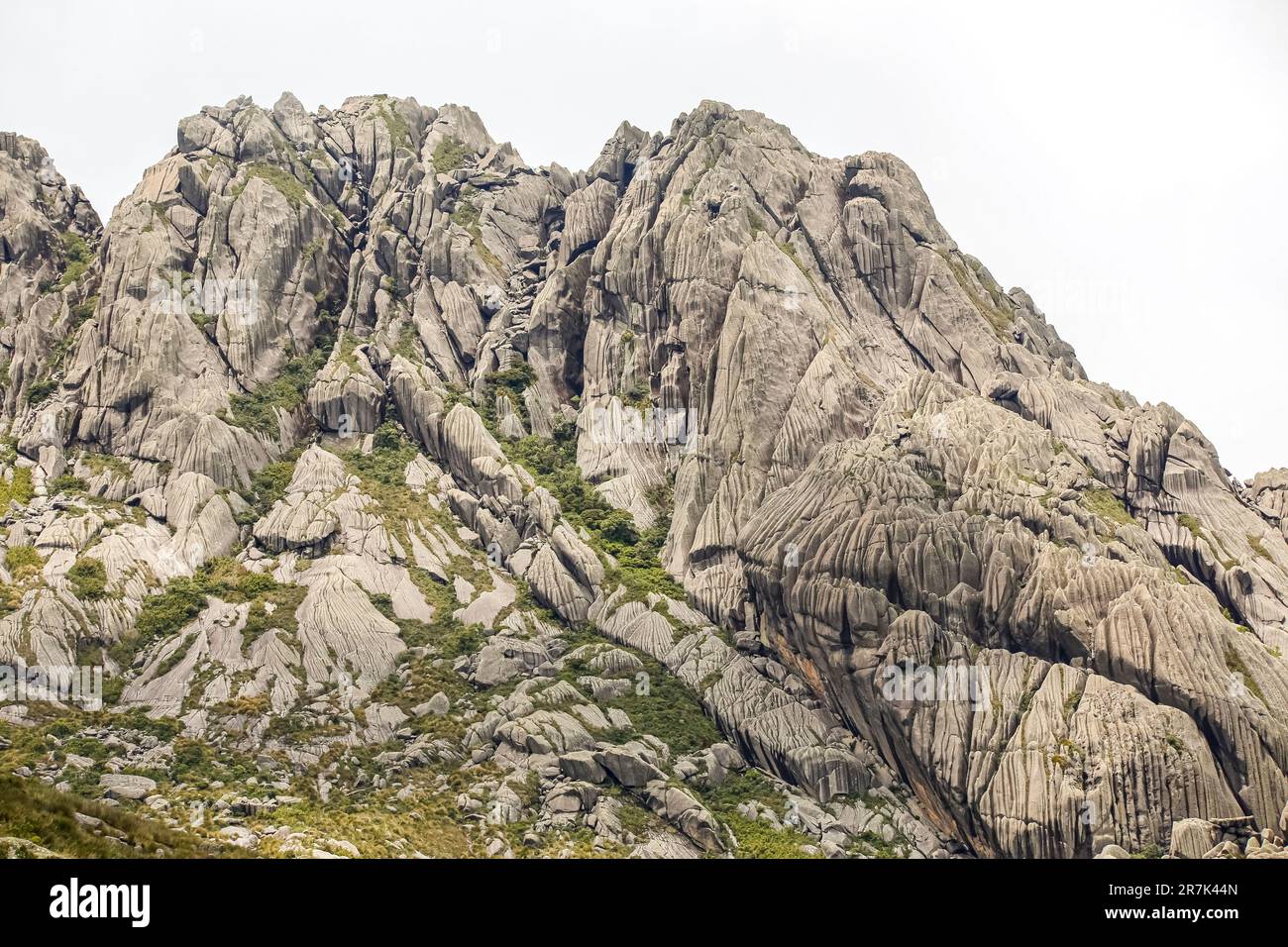 Malerische, zerklüftete Granitberge der Serra da Mantiqueira (Mantiqueira Gebirgskette) mit grasbedeckten Teilen vor hellem Hintergrund, obere Itatiaia, Stockfoto