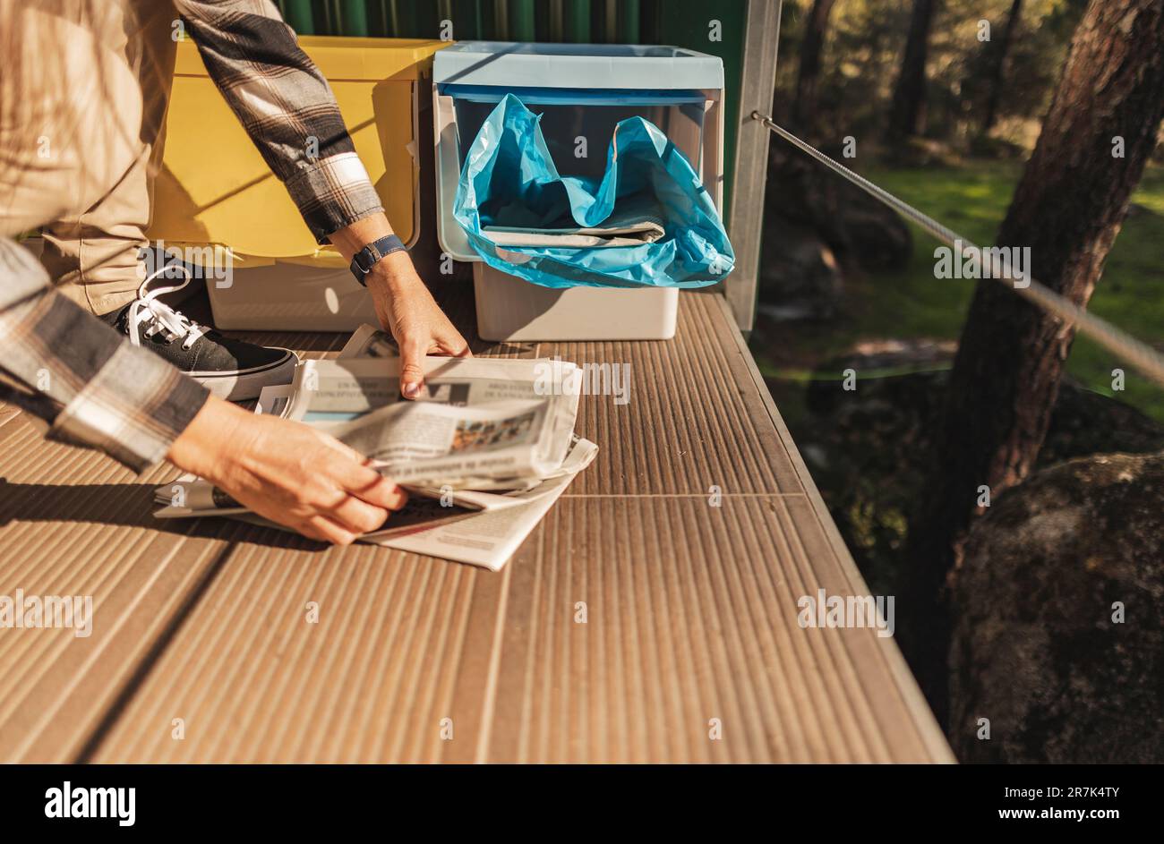 Frau, die Papierabfälle in Mülltrennung wirft Stockfoto