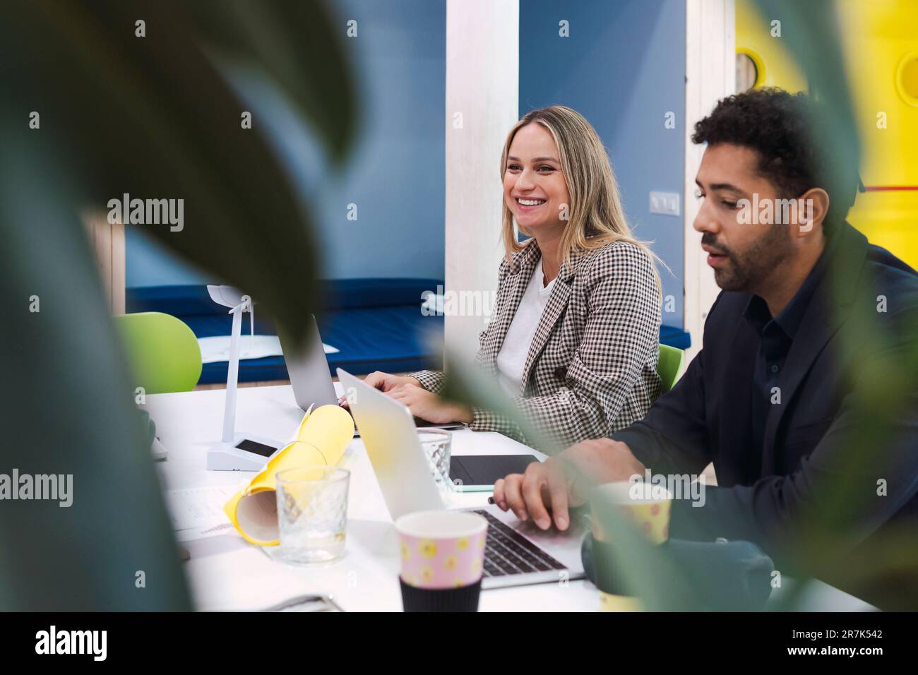 Geschäftskollegen treffen sich mit einem Windkraftmodell auf dem Tisch Stockfoto