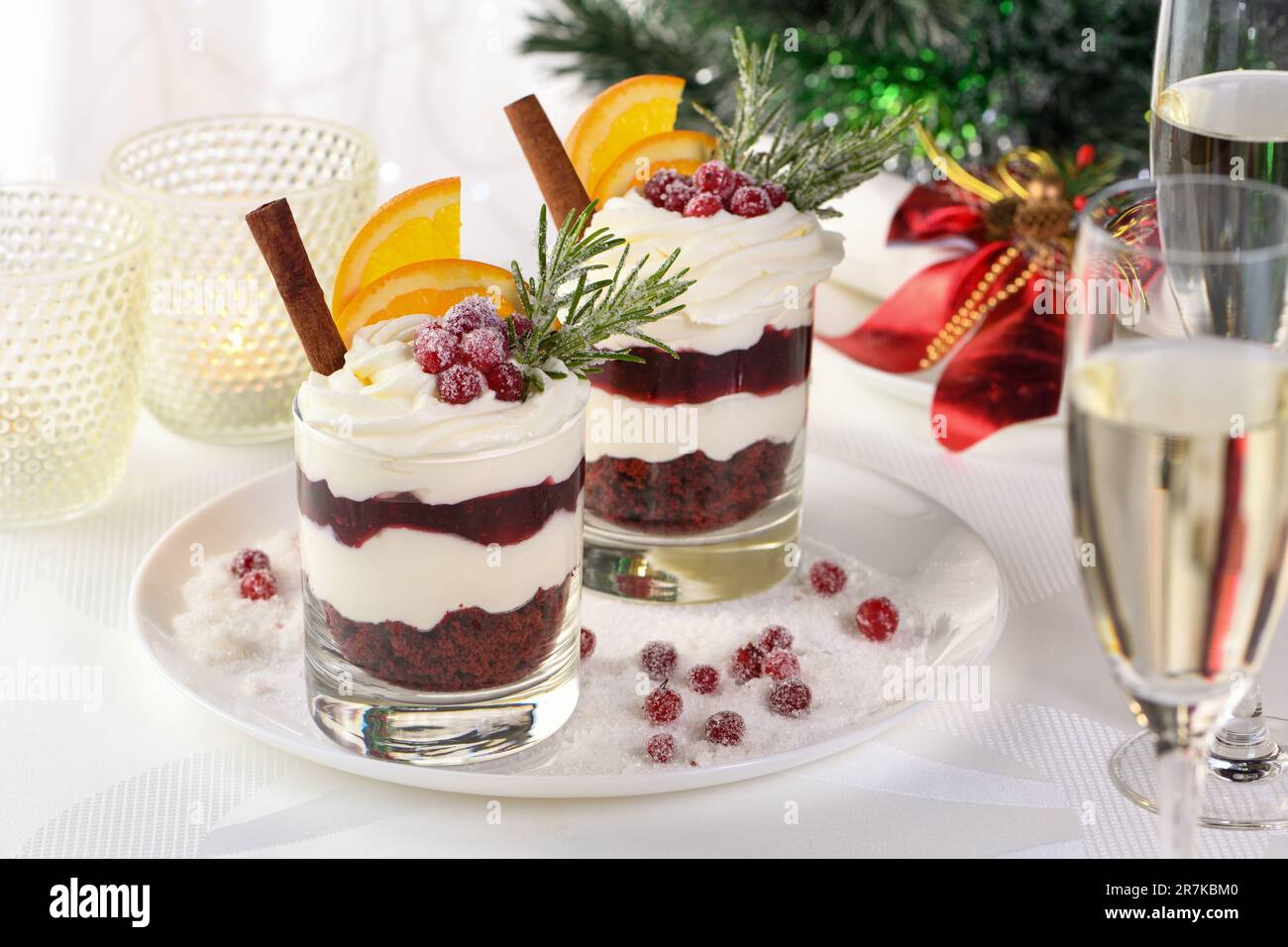 Weihnachts-Cranberry-Dessert-Tiramisu mit Mascarpone und Schlagsahne, Schokoladen-Kekskrümel und Cranberry-Marmelade, garniert mit Orangenscheiben, Dose Stockfoto