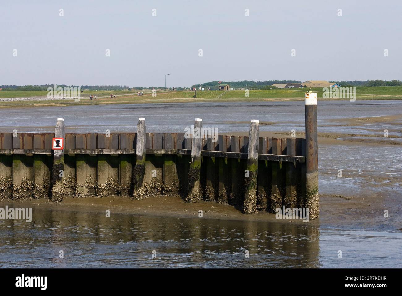 Golfbreker met Dijk in Achtergrond; Wellenbrecher mit Deich im Hintergrund Stockfoto