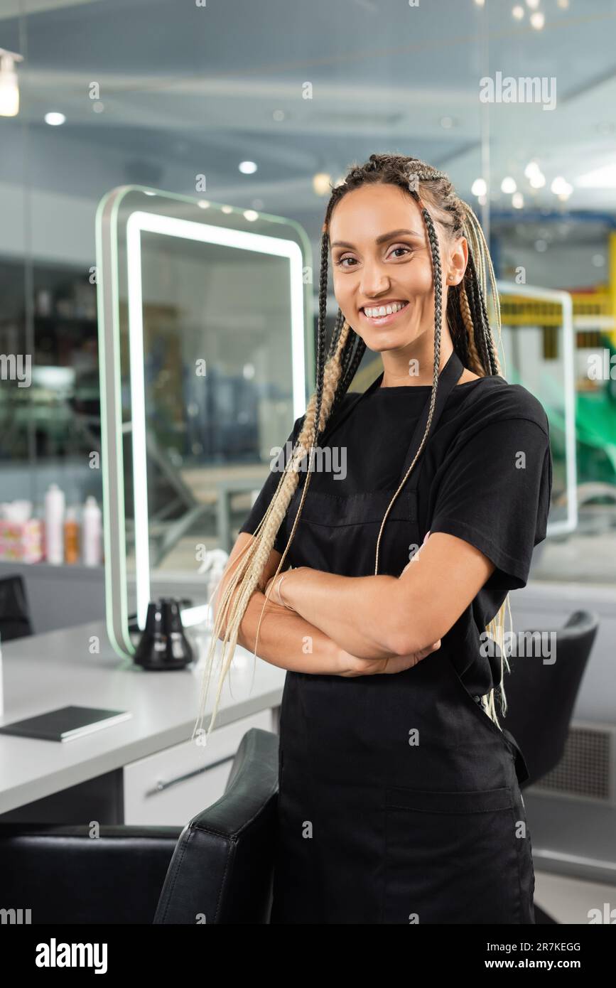 Professionelle Kopfaufnahmen, glückliche Friseurin, Frau mit Zöpfen im Schönheitssalon, Schönheitssalon, Friseurberuf, Friseurarbeit, Haartrends, Positive Einstellung, Innenraum, Stockfoto