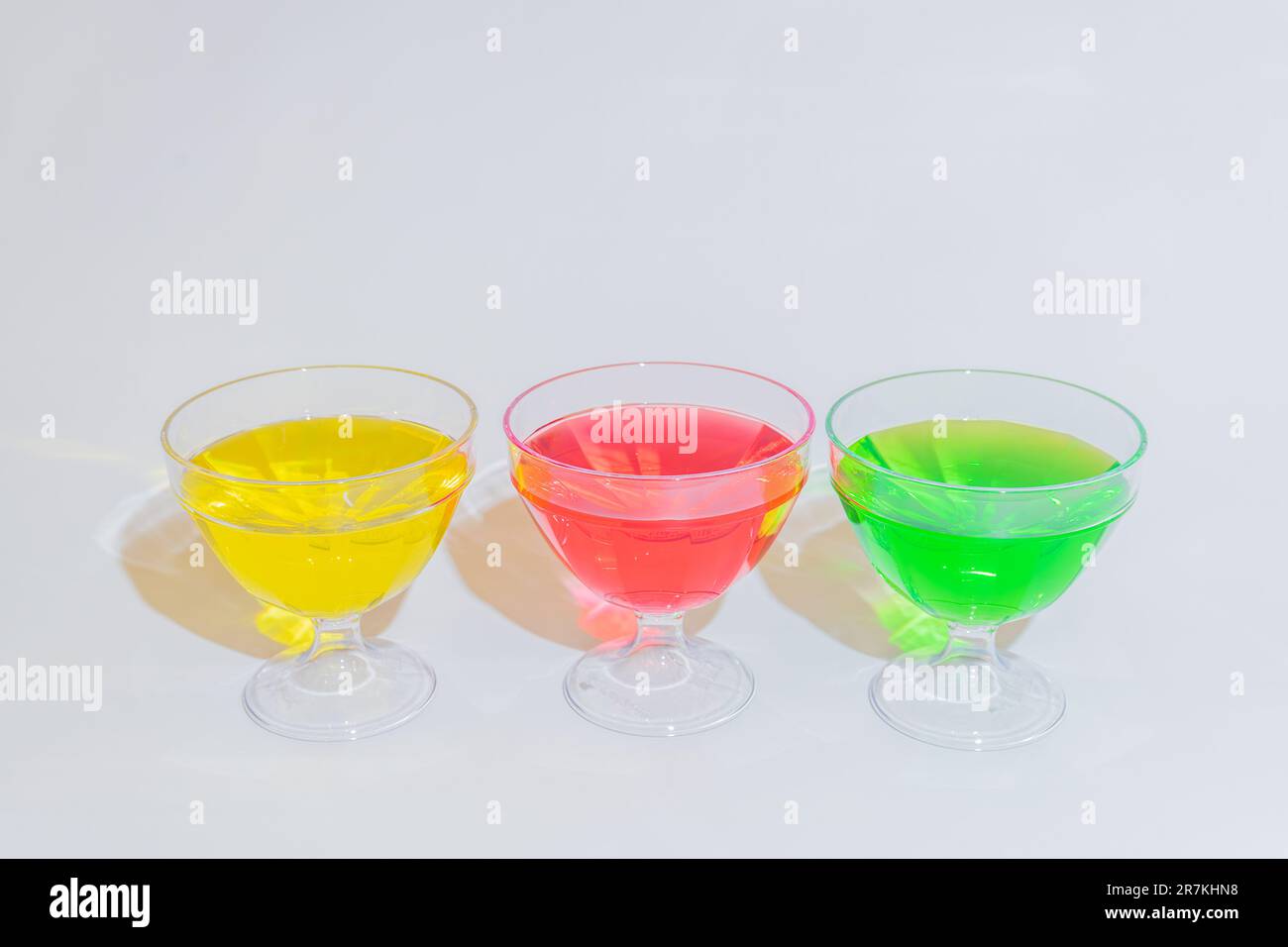 Dieser Becher hat ein einzigartiges Design mit drei verschiedenen Fächern, gefüllt mit köstlichen Sirupen in leuchtenden Rot-, Gelb- und Grüntönen. Stockfoto