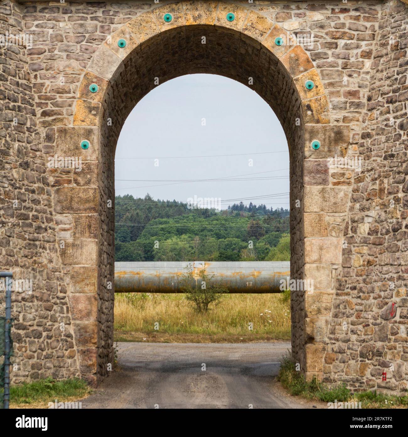 Die Bogenbrücke überquert eine kleine Straße Stockfoto