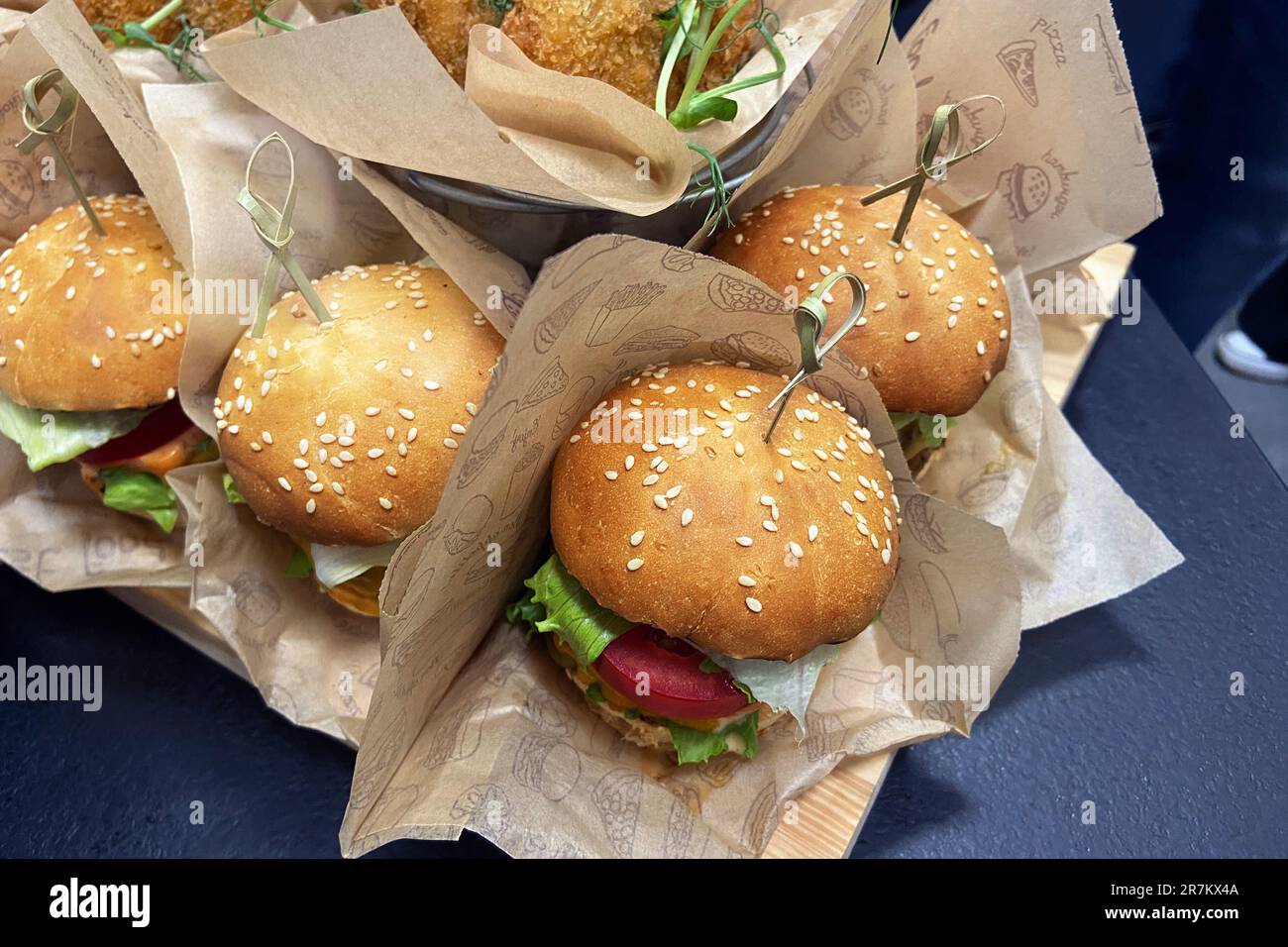 Hamburger zum Verkauf. Gegrillter Burger mit Rindfleisch, Tomaten, Käse, Gurke und Salat. Fastfood zum Mittagessen. Essen. Stockfoto