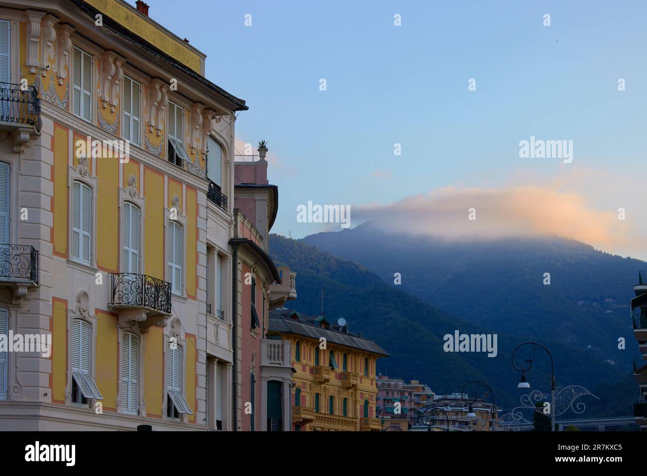 Farbenfrohe Gebäude und Wolken über den Bergen bei Sonnenaufgang, Rapallo, Ligurien, Italien Stockfoto