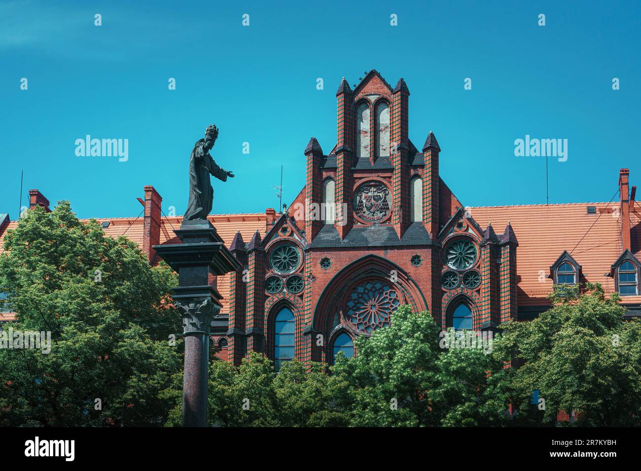 Das neogotische katholische Semestergebäude in Breslau. Skulptur von Jesus Christus in einem Diadem auf einer Säule vor dem Gebäude Stockfoto