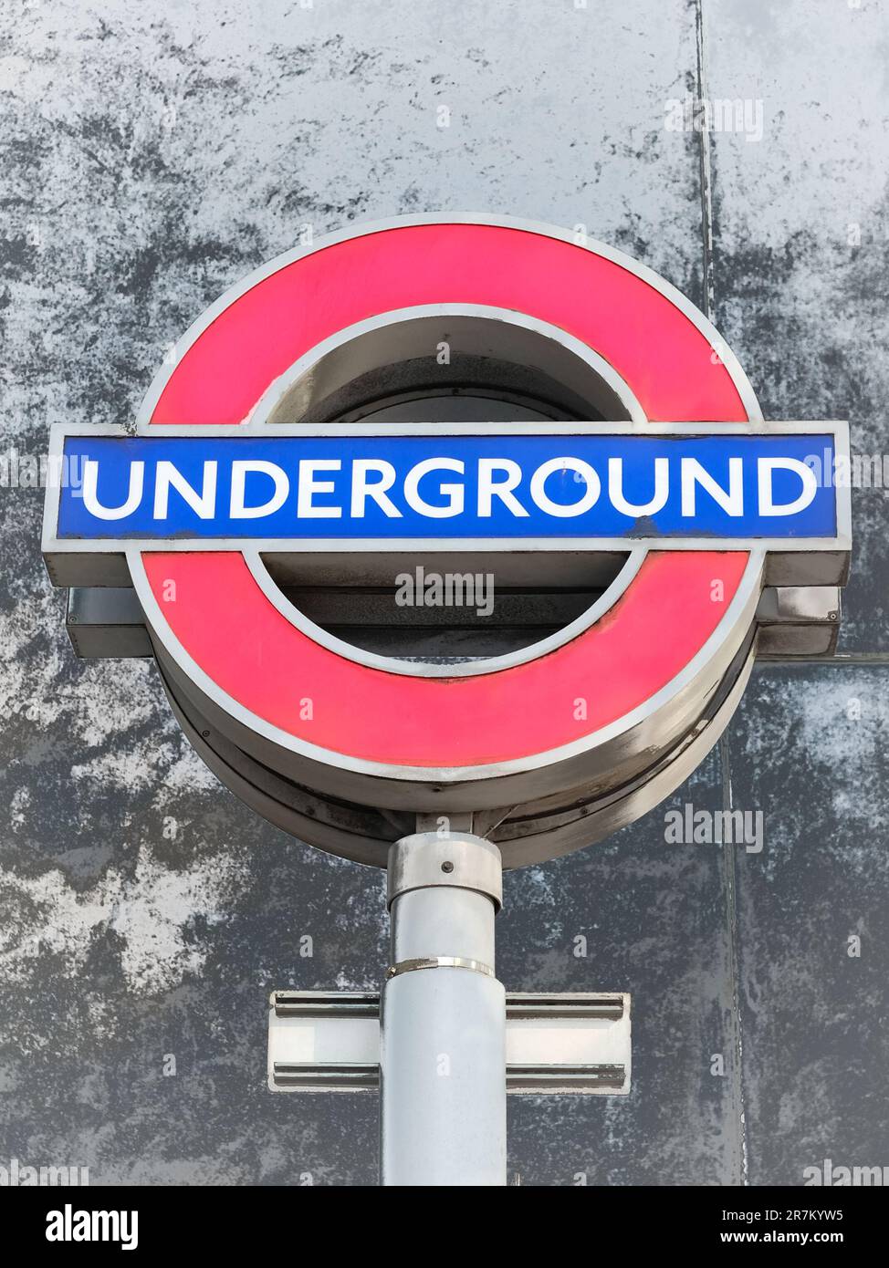 London U-Bahn-Schild mit rotem Kreis und blauer Linie durch das Zentrum Stockfoto