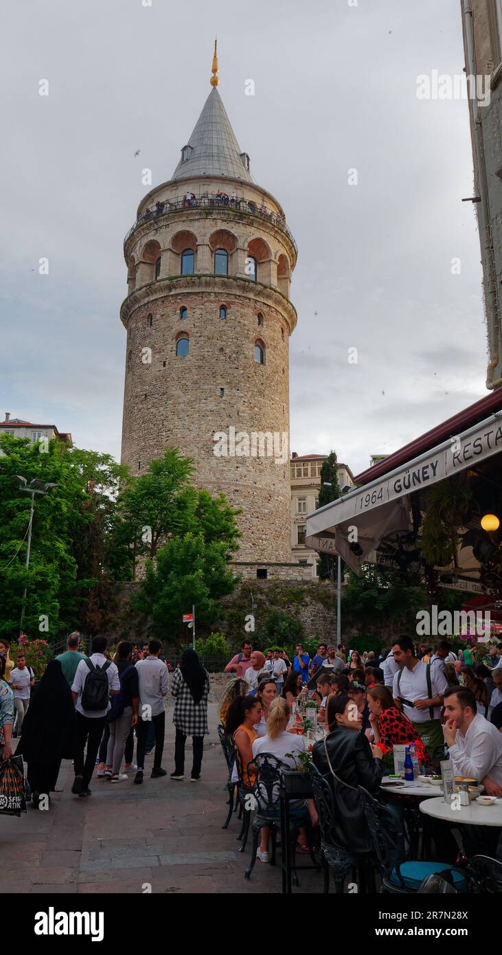 Leute essen draußen in einem Restaurant neben dem Galatenturm. Die Menschen genießen die berühmte Aussicht vom Turm, Galata Viertel, Istanbul, Türkei Stockfoto