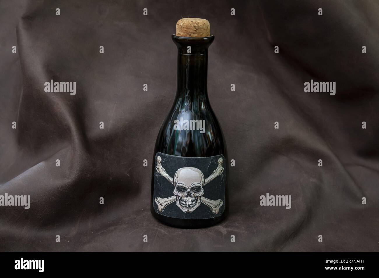 Kleine Flasche Gift, Etikett mit weißem Schädel auf schwarzem Hintergrund Stockfoto