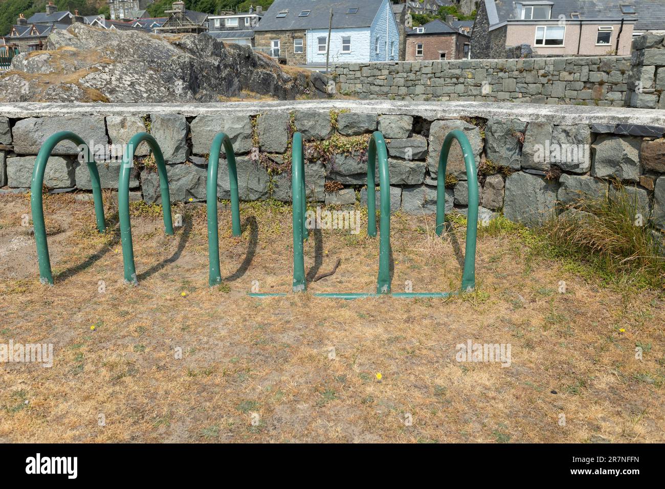 Fahrradständer aus grünem Metall oder Ständer auf festem Untergrund neben Rasen Stockfoto