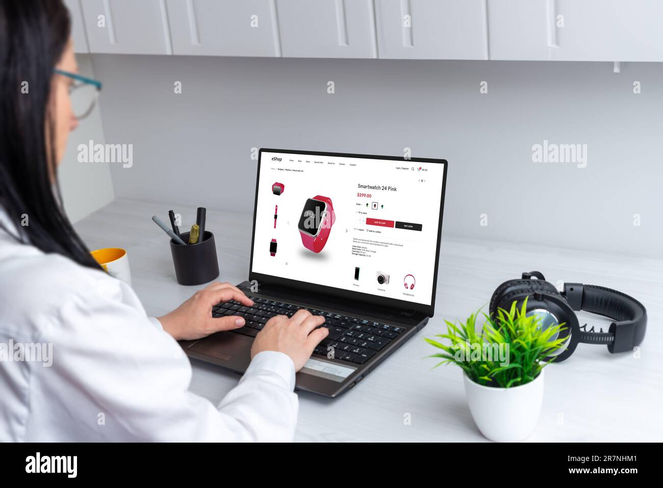 Frau kauft eine Smartwatch online. Einkaufen von zu Hause aus per Laptop. Moderne E-Commerce-Website Stockfoto