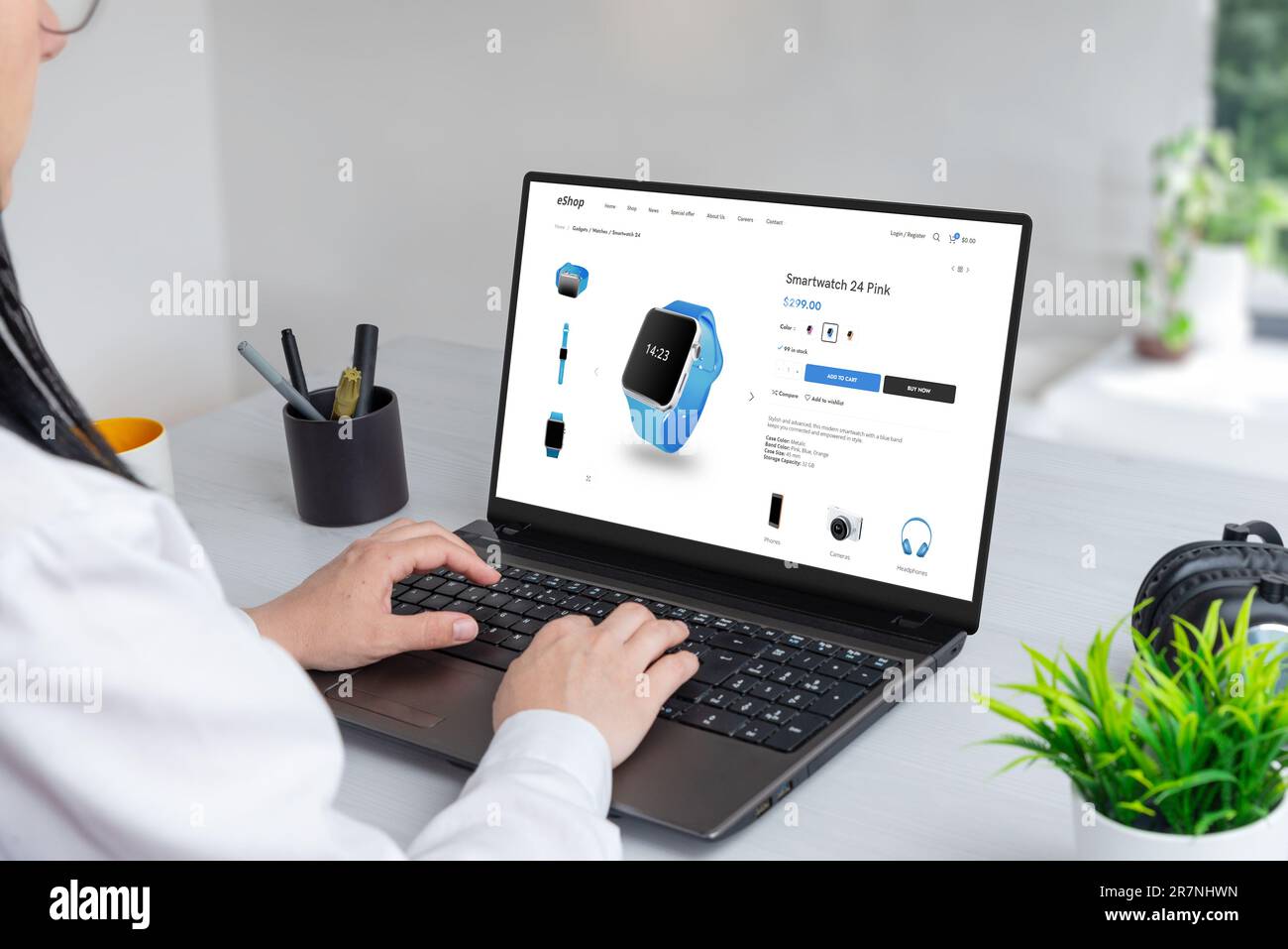 Frau kauft im Internet nach eleganten Smartwatches. Moderne E-Commerce-Webseite auf Laptop-Display Stockfoto