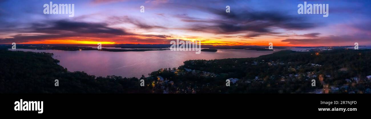 Farbenfroher Sonnenuntergang über dem Lake Macquarie in Australien von der Murrays Beach Panorama Landschaft. Stockfoto