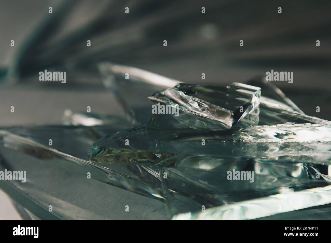 Zerbrochener Glashintergrund für Ihre Bilder, isoliert auf Weiß. Viele große Glassplitter, die aus einem Hammer als Begriff der Gewalt zerstreut werden Stockfoto