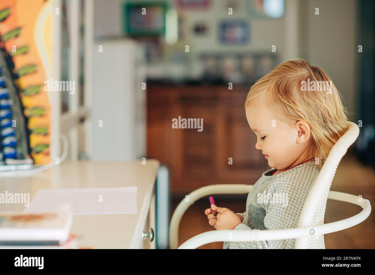 Süßes kleines Mädchen, das am Schreibtisch sitzt, bereit zum Zeichnen Stockfoto