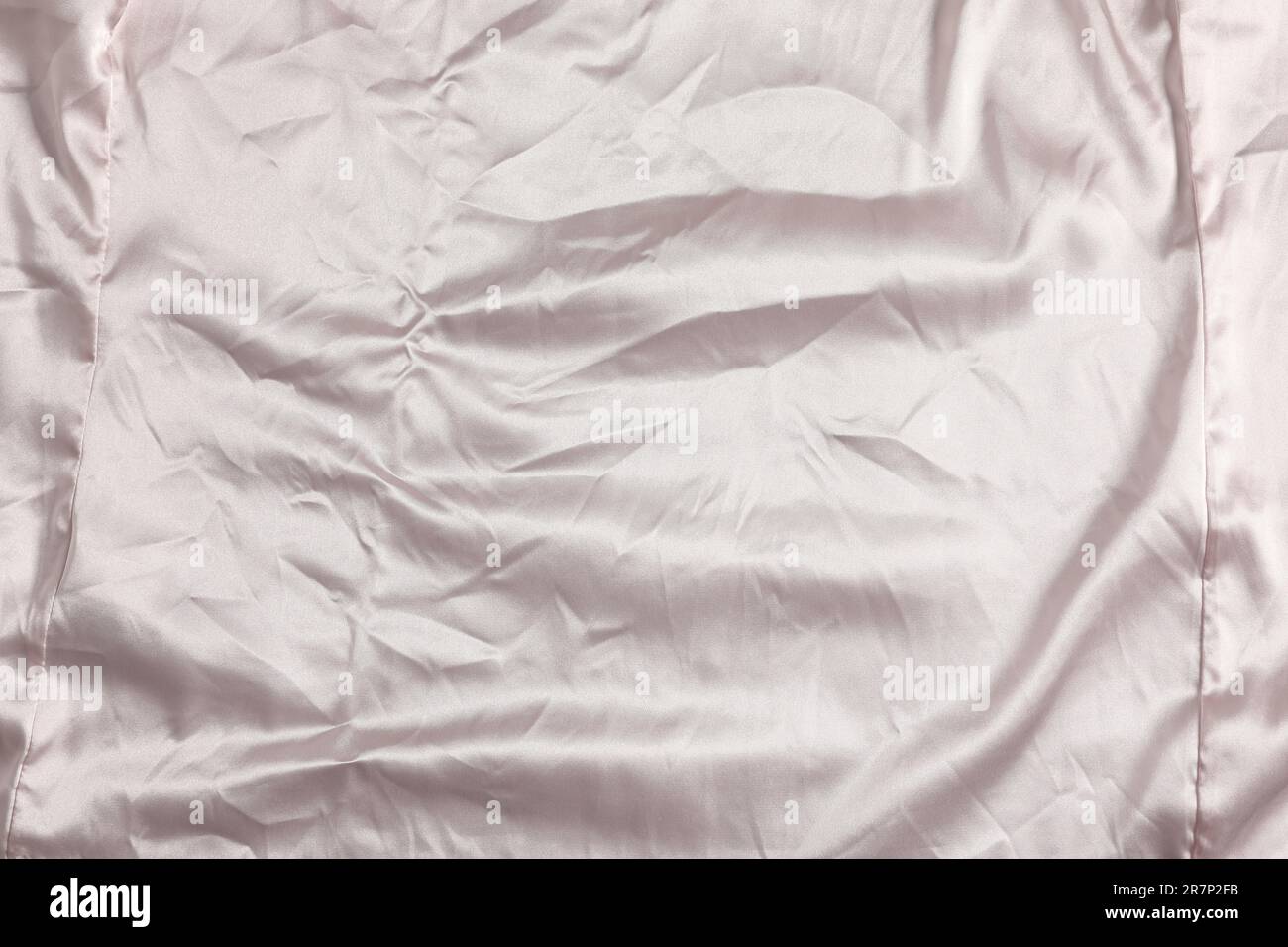 Zerknittertes hellrosa Material als Hintergrund, Draufsicht Stockfoto