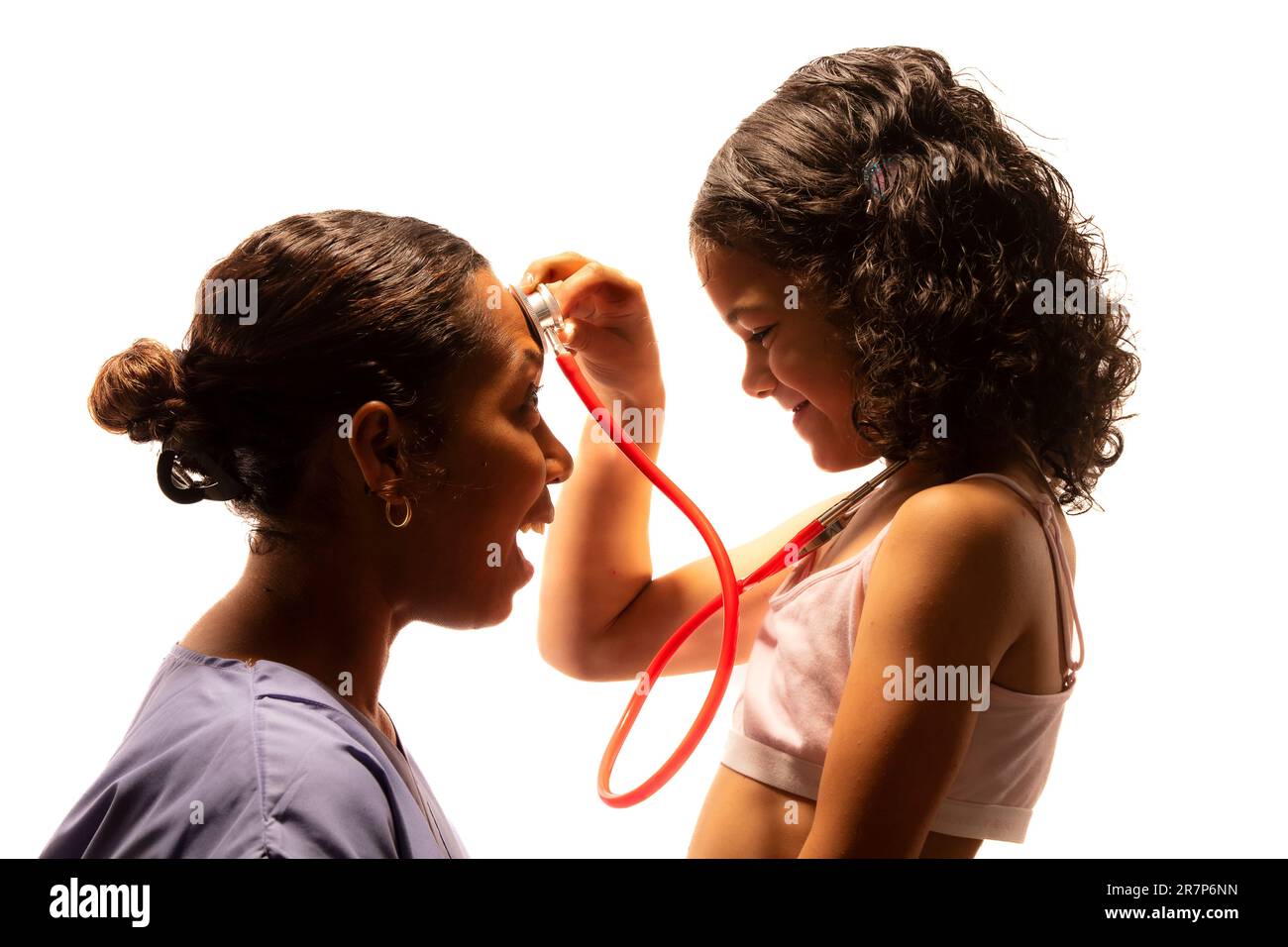 Junge Frau, die mit dem Stethoskop eines Arztes spielt. Stockfoto