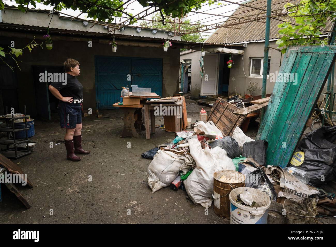 Eine Assistenzärztin steht und reagiert auf ihr beschädigtes Haus in