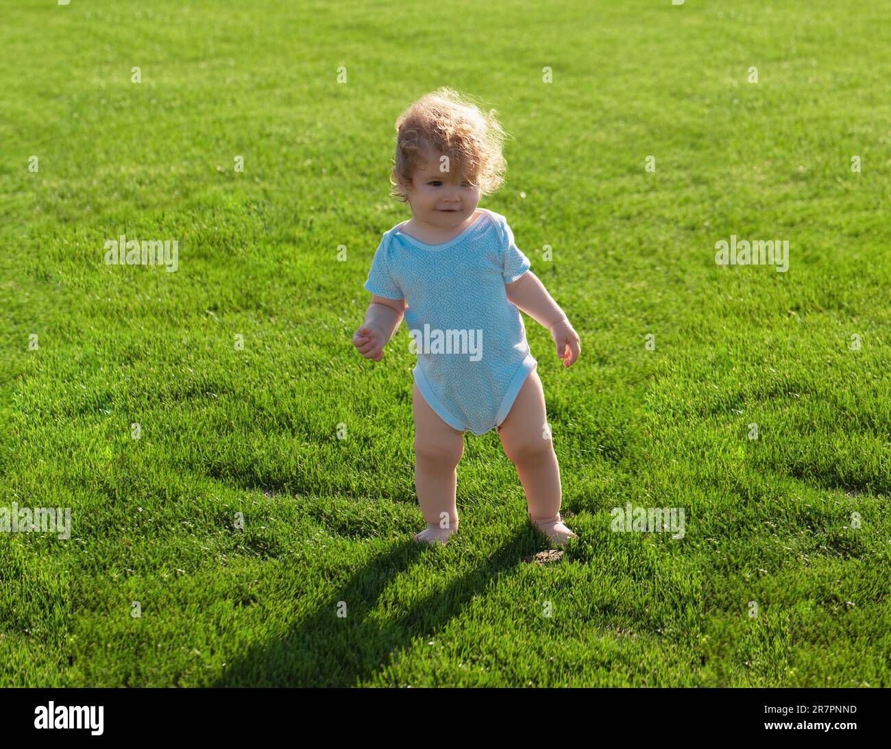 Baby Junge Kleinkind zu Fuß in einem Park am hellen Frühlingstag. Entwicklung von Kindern Stockfoto