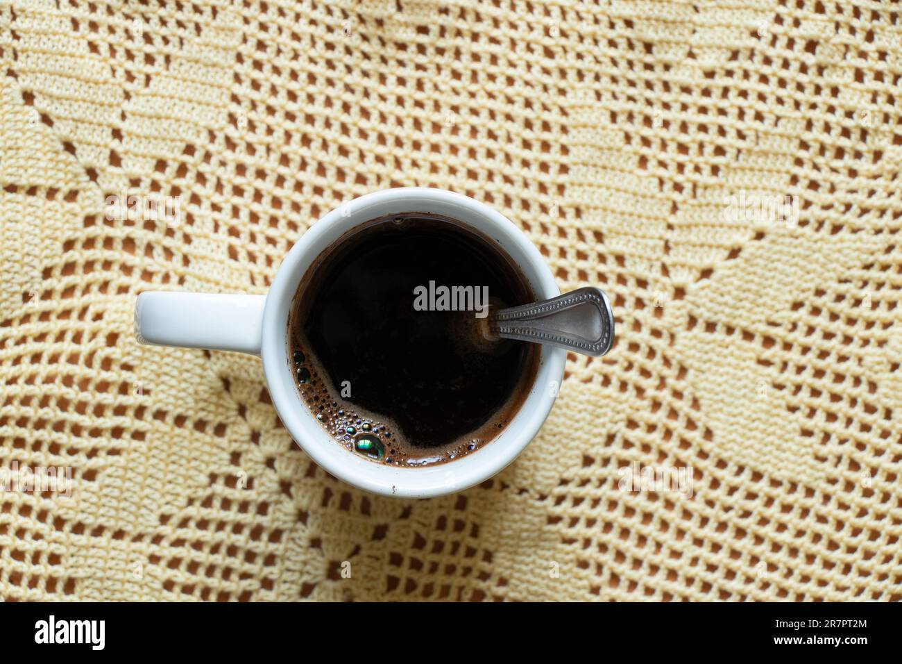 Eine Tasse heißen schwarzen Kaffees mit einem Löffel auf der Tischplatte nach unten Stockfoto