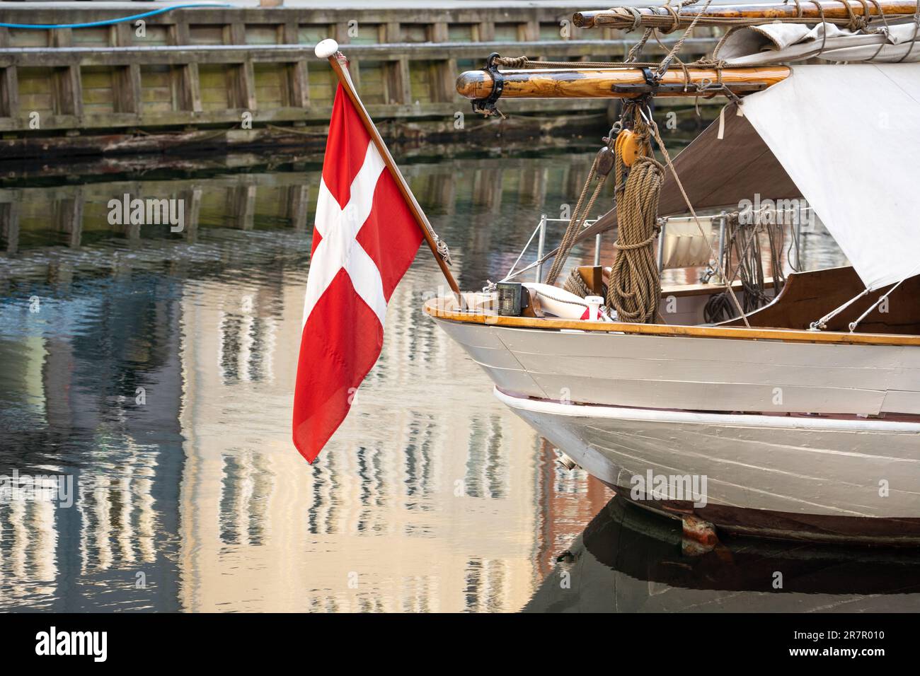 Dänische Flagge hängt am Heck eines Segelbootes auf einem Kanal in Kopenhagen, Neuseeland, Dänemark Stockfoto