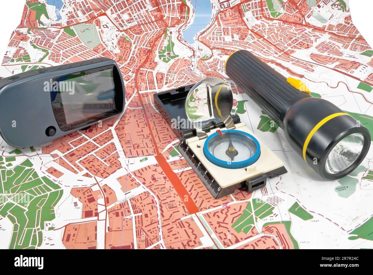 Auf einer Topokarte befinden sich ein tragbares GPS, eine Taschenlampe und eine Kompasseinheit Stockfoto