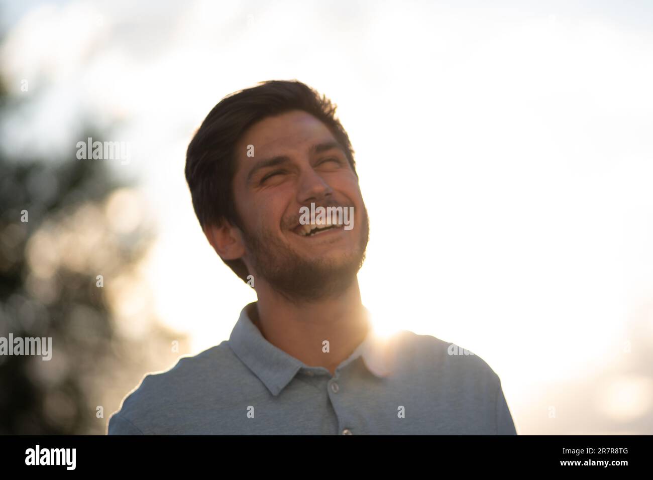 Porträt eines jungen Mannes an einem sonnigen Tag: Gebadet im Sonnenlicht, enthüllt seine jugendliche Lebendigkeit und die strahlende Energie des Tages. Stockfoto Porträt eines jungen Mannes an einem sonnigen Tag: Gebadet im Sonnenlicht, enthüllt seine jugendliche Lebendigkeit und die strahlende Energie des Tages. Stockfoto