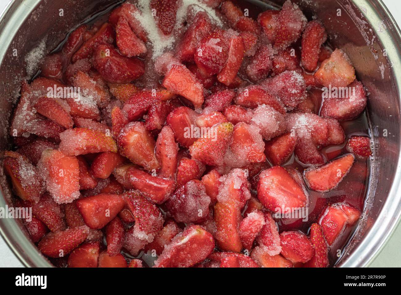 Frische Erdbeeren, mit Zucker bestreut, um Marmelade zu machen. Papierstau verursachen. Rote und reife Erdbeeren mit Zucker bestreut Stockfoto