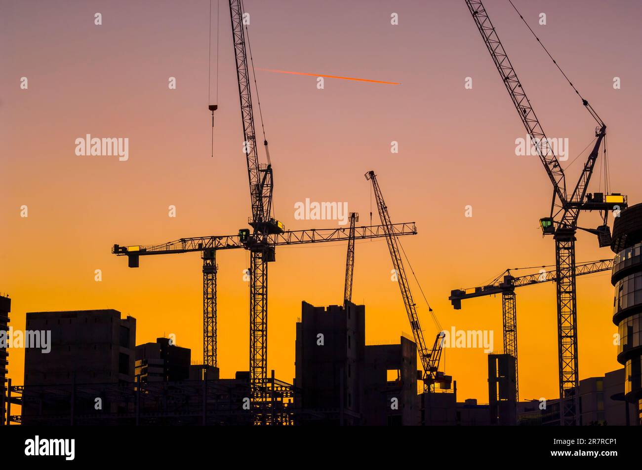 Krane, die in neuen Gebäuden im Bau in der Dämmerung verwendet werden, London, England, Großbritannien Stockfoto