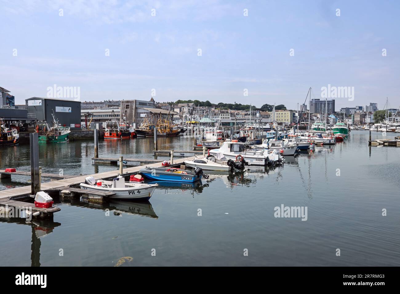 Plymouth Sutton Harbour, der Fischmarkt mit Fischerbooten und kleineren Handwerkern im Vordergrund, in der Ferne der Barbican Stockfoto