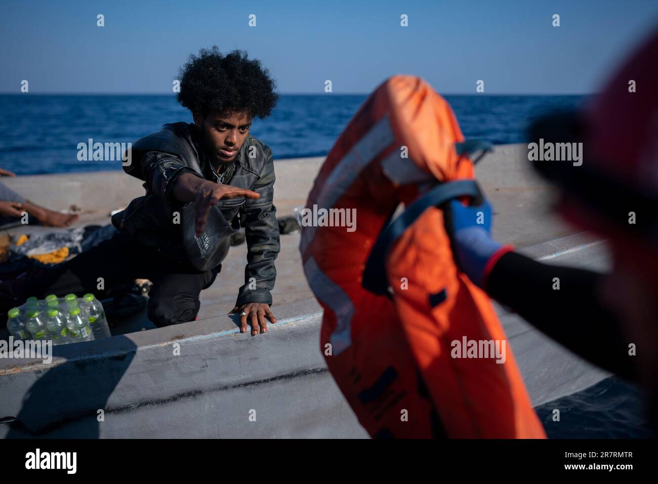 A migrant is assisted by aid workers of the Spanish NGO Open Arms, in the Mediterranean sea, about 30 miles north of Libya, Saturday, June 17, 2023. (AP Photo/Joan Mateu Parra) Stockfoto