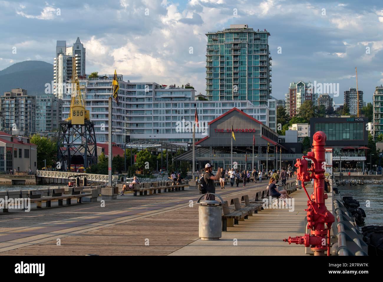 Vancouver, BC, Kanada - Juli 2022; Blick vom Dock der ehemaligen Burrard Dry Dock Company, heute die Werften, mit entspannenden Menschen in Stühlen mit Blick auf w Stockfoto