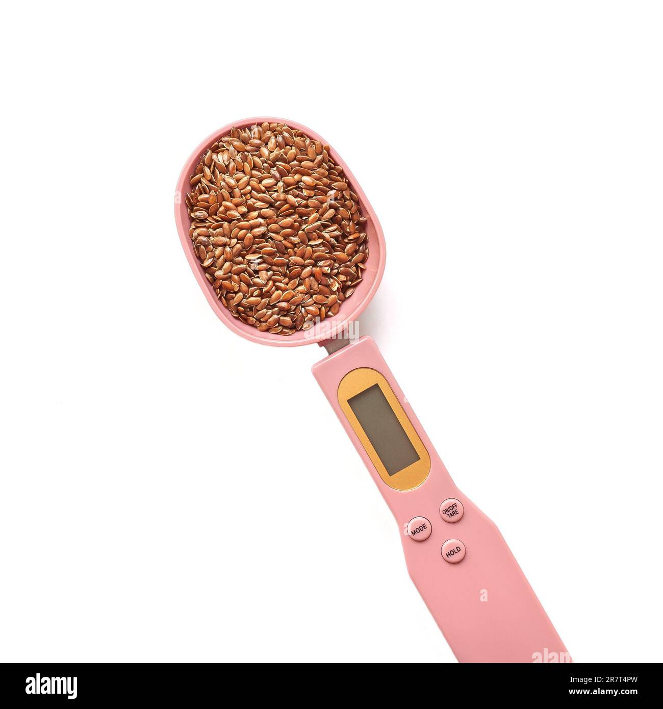 Braune Leinsamen in einem rosafarbenen elektronischen Messlöffel auf weißem Hintergrund. Superfoods, gesunde Ernährung Konzept und Keto Diät Stockfoto