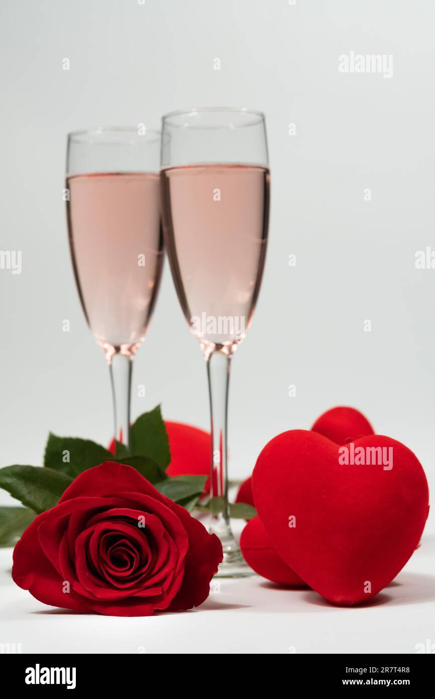 Champagnergläser, eine Rose und Herzen valentinstag mit weißem Hintergrund und Kopierraum Stockfoto