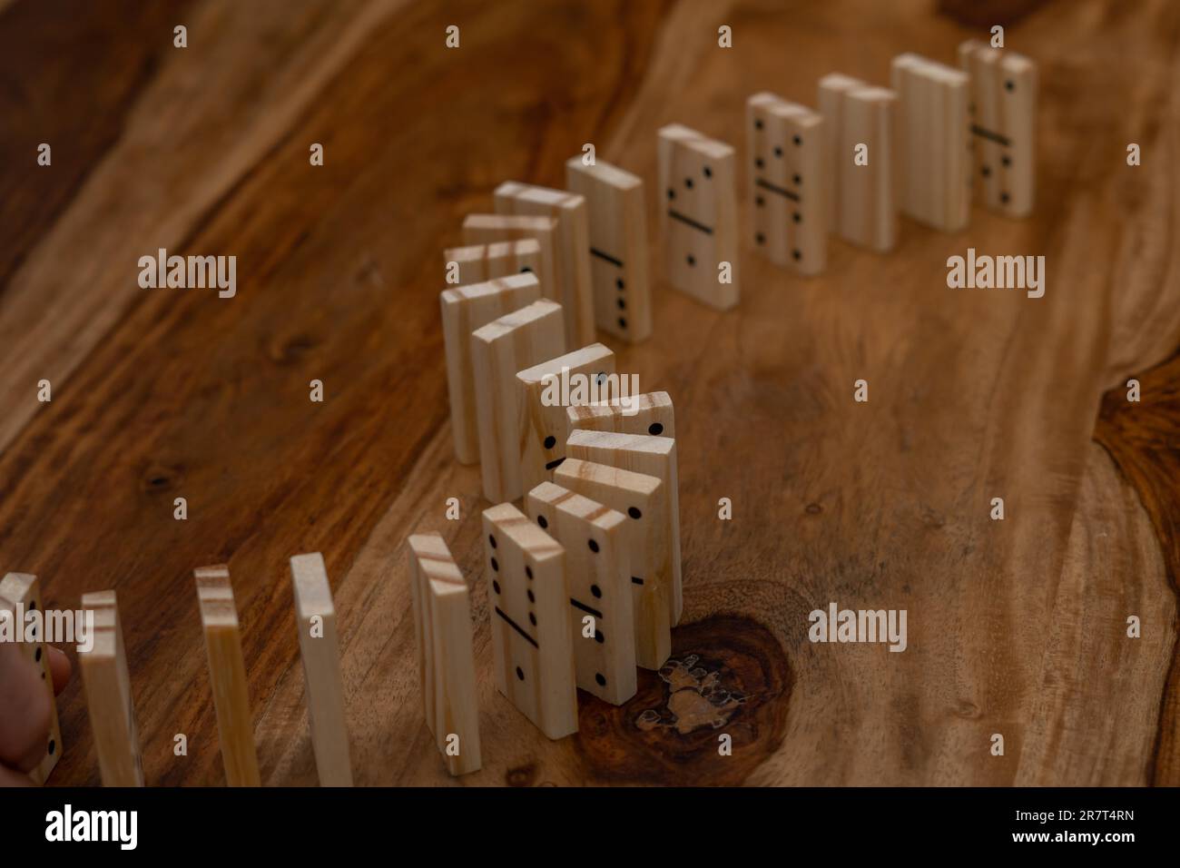 Hölzerne Dominosteine in einer Reihe auf einem Holztisch Stockfoto