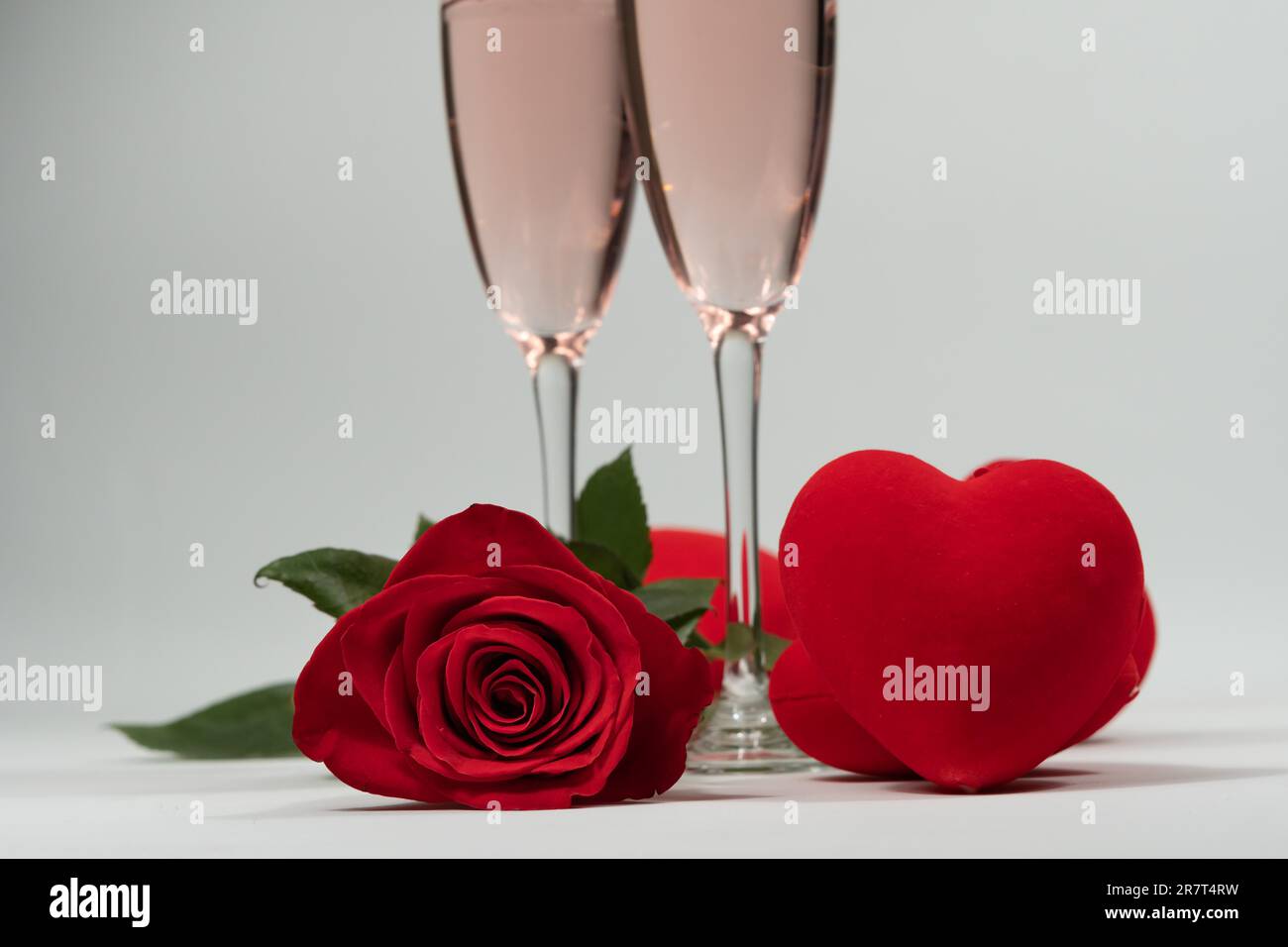 Champagnergläser, eine Rose und Herzen valentinstag mit weißem Hintergrund und Kopierraum Stockfoto